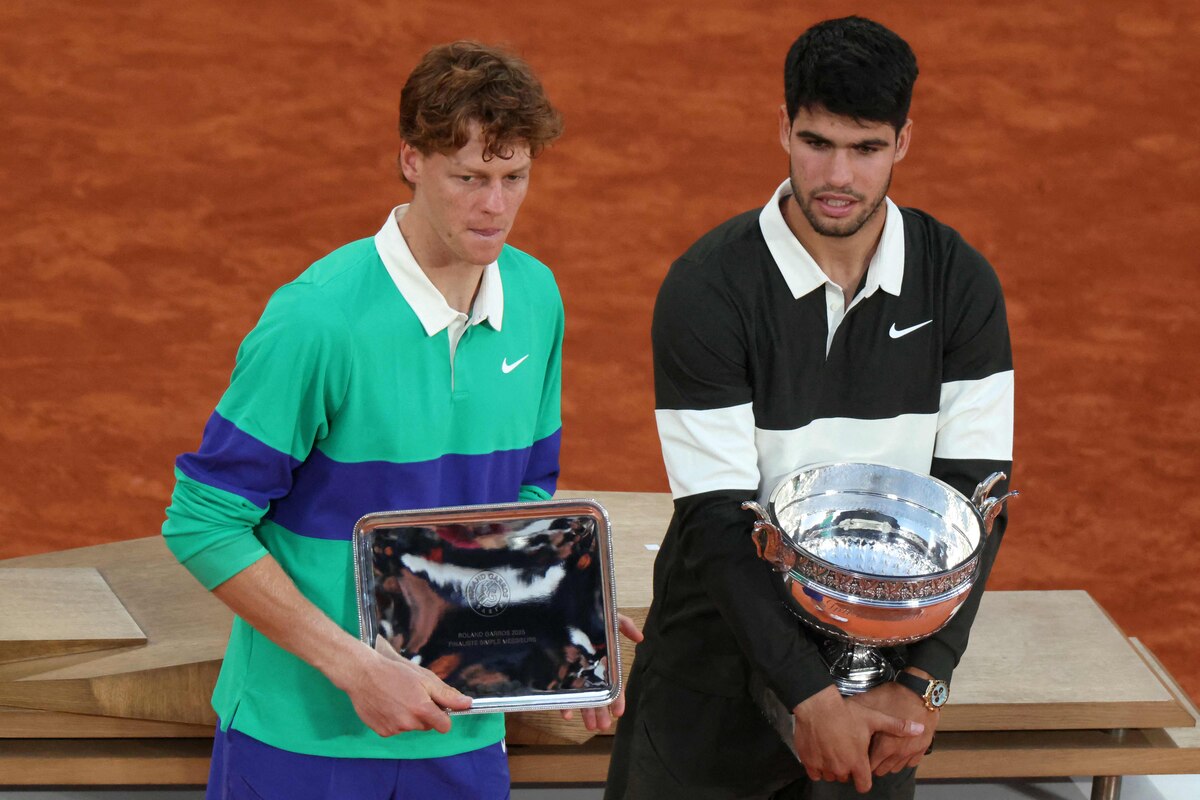 Winner Spain's Carlos Alcaraz (R) and finalist Italy's Jannik Sinner pose with their respective trophies after their men's singles match on day 15 of the French Open tennis tournament on Court Suzanne-Lenglen at the Roland-Garros Complex in Paris on June 8, 2025. (Photo by Alain JOCARD / AFP)