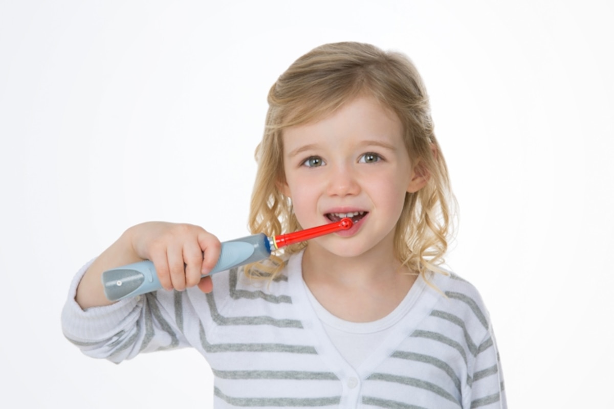 Enfant avec une brosse à dents électrique pour enfant