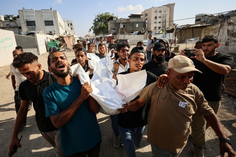 <p>Des personnes endeuillées portent le corps de l'un des trois Palestiniens mortellement touchés par une frappe israélienne sur une université de Gaza, le 25 octobre 2026</p>
