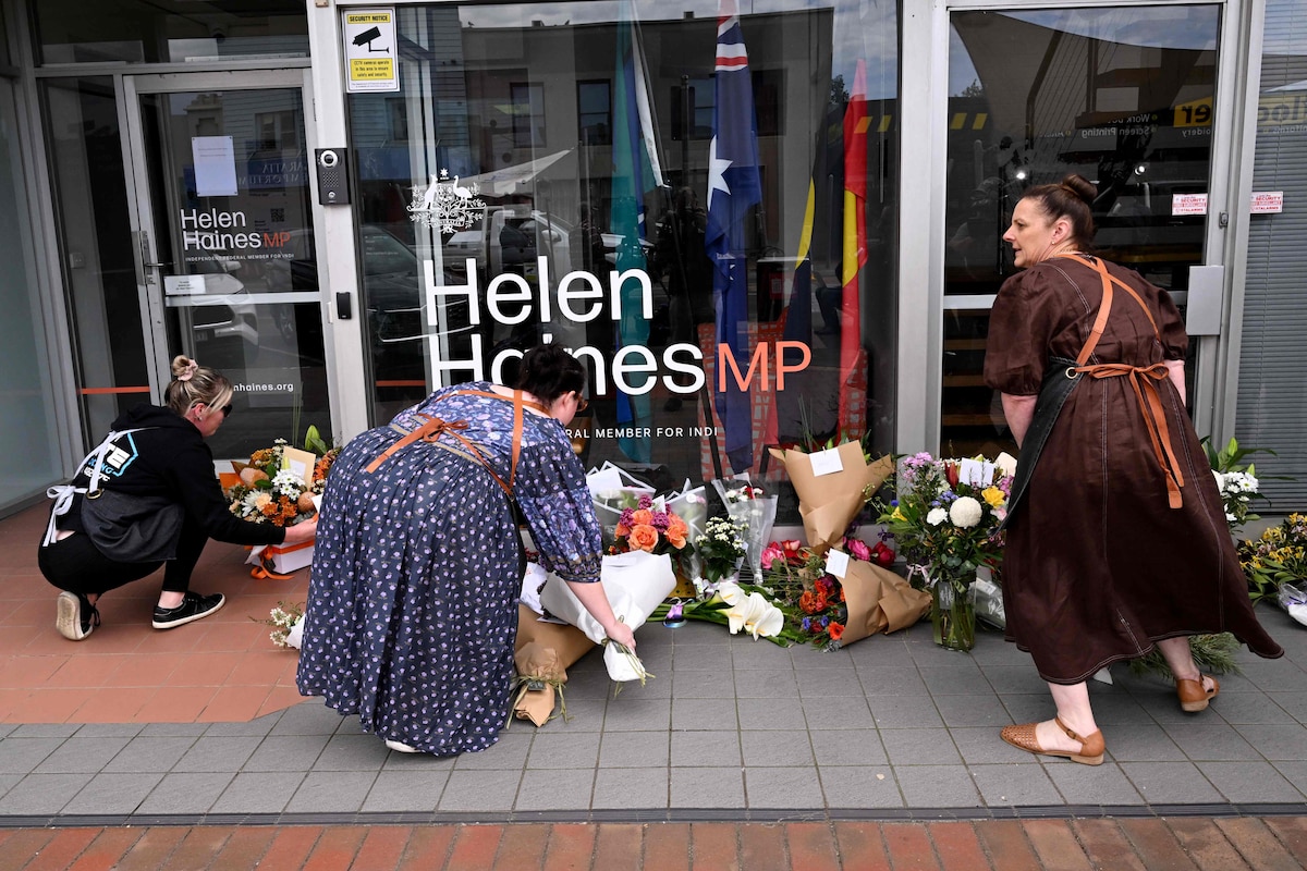 People lay flowers outside the office of Australian politician Helen Haines in the northern regional city of Wangaratta, some 250 kilometres north-east of Melbourne on October 20, 2026. Australian independent lawmaker Helen Haines underwent surgery overnight but remains in a critical condition after being struck deliberately by a car in an attack, Prime Minister Anthony Albanese said on October 20. (Photo by William WEST / AFP)