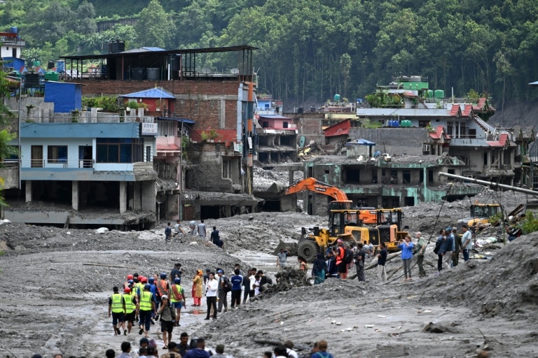 <p>Des pelleteuses dégagent la boue et les décombres après la crue destructrice qui a fait au moins 633 morts à la frontière entre le Népal et la Chine, le 29 août 2026 à Dhunge Bazaar, dans le district népalais de Nuwakot</p>