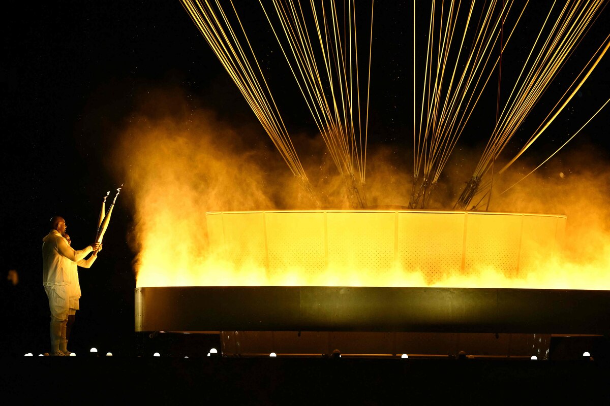 Torchbearers France's judoka Teddy Riner and sprinter Marie-Jo Perec light the Olympic cauldron during the opening ceremony of the Paris 2024 Olympic Games in Paris on July 26, 2024. (Photo by Ben STANSALL / AFP)