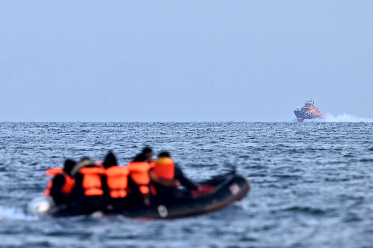 (FILES) Royal National Lifeboat Institution (RNLI) Severn class lifeboat, the City of London II, makes its way towards migrants travelling in an inflatable boat across the English Channel, bound for Dover on the south coast of England. Nearly 30,000 migrants crossed the Channel to the UK from mainland Europe in small boats in 2023, an annual drop of more than a third, government figures released on January 1, 2024 showed. However, the unauthorised arrivals of 29,437 people on the southeast English coast remains the second largest yearly tally since officials began publishing such numbers in 2018. (Photo by Ben Stansall / AFP)
