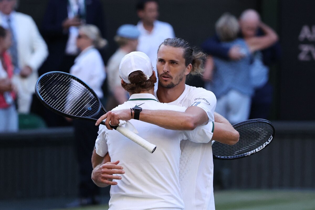 Italy's Jannik Sinner hugs Germany's Alexander Zverev (R) after winning during their men's singles final tennis match on the fourteenth day of the 2026 Wimbledon Championships at The All England Lawn Tennis and Croquet Club in Wimbledon, southwest London, on July 12, 2026. (Photo by Henry NICHOLLS / AFP) / RESTRICTED TO EDITORIAL USE