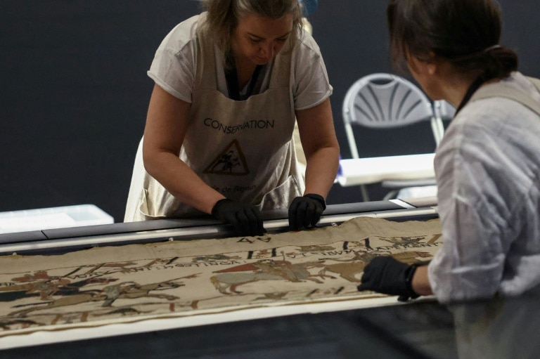 <p>Des employées préparent la tapisserie de Bayeux présentée aux médias au British Museum, le 17 juillet 2026 à Londres</p>