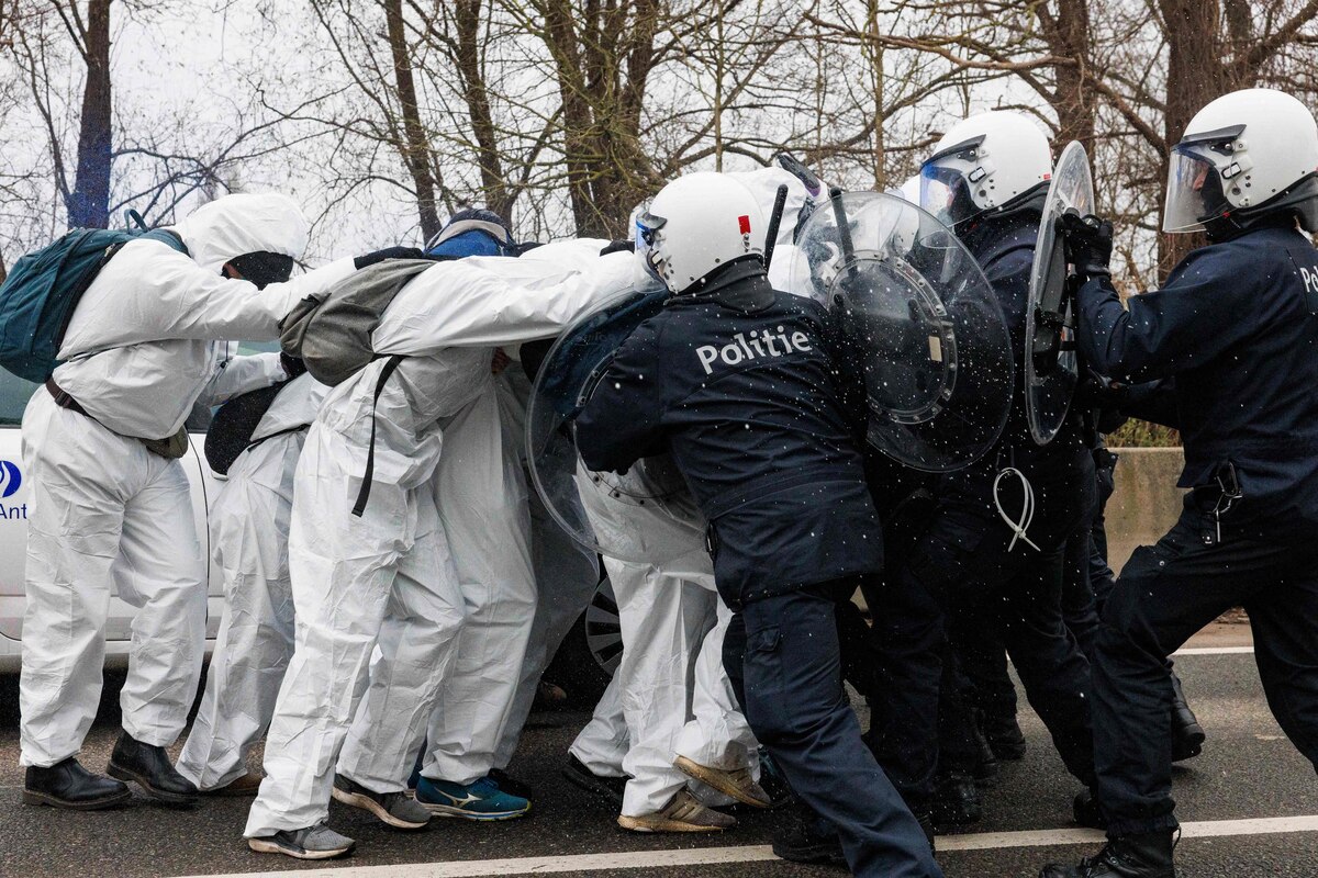 Environmental activists of the "code rouge" coalition clash with police officers during a demonstration against the aviation industry in Antwerp, on December 16, 2023. (Photo by Simon Wohlfahrt / AFP)